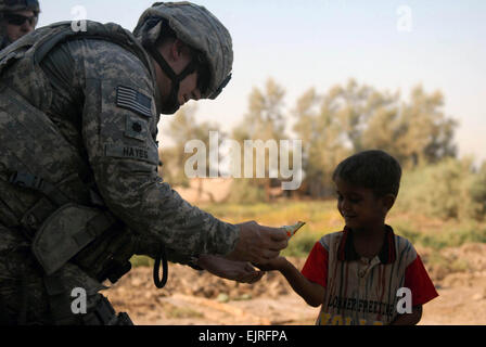 Lt. Col. Jason Hayes, the commander of the 2nd Battalion, 5th Cavalry Regiment, 1st Brigade, 1st Cavalry Division, gives a child trail mix in Iraq, Sept. 5. Stock Photo
