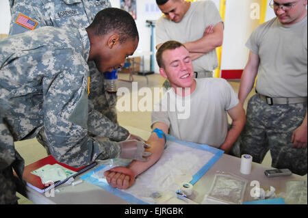 Private Josh Jordan of Savannah, Ga., administers and IV on Spc. Eddie Washington of Oceanside, Calif., during Combat Lifesaver Course in Colorado Springs, Colo., March 11, 2009. Jordan and Washington are both assigned to Headquarters and Headquarters Battery, 3rd Battalion, 157th Field Artillery, Colorado Army National Guard.   Staff Sgt. Liesl Marelli, Colorado Army National Guard Released Stock Photo