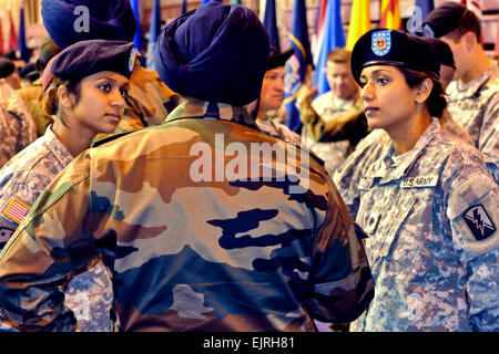 U.S. Army Cpl. Balreet Kaur and Spc. Jasleen Kaur, Indian-born sisters, compare common courtesies of the United States and India with an Indian soldier before the opening ceremony for the combined training exercise Yudh Abhyas on Joint Base Elmendorf-Richardson, Alaska, Oct 31. 2010. Balreet and Jasleen are California National Guardsmen assigned to the 79th Infantry Brigade Combat Team. Both are medics and cultural liaisons for the 14-day exercise.  Spc. Ashley M. Armstrong Stock Photo