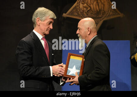 Secretary of Army John McHugh, left, presents the Medal of Honor flag to Pete Corrall, on behalf of his uncle, Sgt. Eduardo C. Gomez, one of 24 Army veterans honored during the Valor 24 Hall of Heroes Induction ceremony, held at the Pentagon, Washington D.C., March 19, 2014.  Mr. Leroy Council Stock Photo