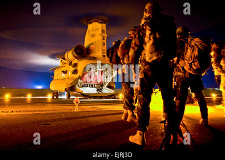 A group of Afghan Commandos, with 3rd Commando Kandak, and U.S. Special Forces Soldiers, with Special Operations Task Force - South, wait to board a CH-47 Chinook helicopter before an operation to rid insurgents from PanjwaÕi District, Oct. 15, 2010, in Kandahar Province, Afghanistan.  Spc. Daniel P. Shook/Special Operations Task Force - South Stock Photo