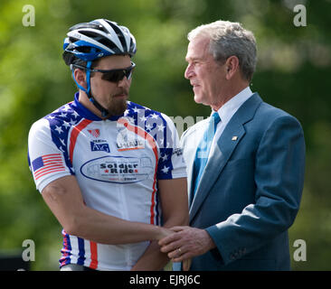 President George W. Bush speaks to a Wounded Warrior Project's Soldier rider on the South Lawn of the White House April 24, 2008. The event provides rehabilitative cycling events for severely injured service members, affording many of the combat-wounded veterans a way to return to an active lifestyle.  Mass Communication Specialist 1st Class Chad J. McNeeley, U.S. Navy. Released Stock Photo