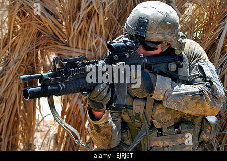 A U.S. Army soldier uses the scope on his M 4 rifle to scan the ...