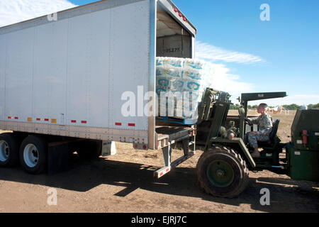 Army Staff Sgt. Lynda Santiago, a supply sergeant with the Colorado Army National Guard's Headquarters and Headquarters Company, 147th Brigade Support Battalion, uses a forklift to offload pallets of water as part of relief and recovery operations near Fort Collins, Colo., Wednesday, Sept. 18, 2013. More than 750 guard members have been working with local, state and federal authorities in response to flooding in central Colorado as a result of heavy rains in the area. Colorado Guard members have evacuated about 700 people by ground and military aerial evacuations currently total 2,394.  Sgt. 1 Stock Photo