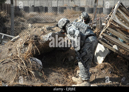 U.S. Army Staff Sgt. Eric Hummel, with the 2nd Brigade, 1st Infantry Division, searches for weapons caches in Ameriyah, Iraq, Feb. 7, 2009. Stock Photo