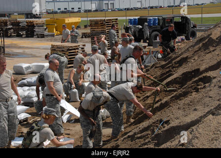 U.S. Soldiers from the Indiana Army National Guard fill sandbags for flood control efforts at the Indiana Department of Transportation office in Vincennes, Ind., June 10, 2008. The Soldiers and U.S. Marines and Sailors assigned to the 26th Marine Expeditionary Unit are helping state and local authorities raise the White River levee in an attempt to prevent further flooding in the area.  Senior Master Sgt. John S. Chapman, Stock Photo