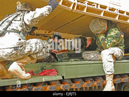 U.S. Army combat engineers assigned to 837th Engineer Company, Ohio Army National Guard out of Cleveland, Ohio, perform preventative maintenance checks on an armored vehicle launched bridge during familiarization training on Camp Grayling, Mich., June 11, 2008. The vehicle weighs more than 55 tons and is capable of extending the bridge up to 60 feet, allowing other personnel and equipment to cross over gullies, ravines and other chasms.  Spc. Zachary R. Fehrman, Stock Photo