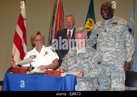 Cathy Lanier seated, left, chief of the Metropolitan Police of the District of Columbia, and Army Maj. Gen. Peter Cook from the Army Reserve sign a partnership agreement to collaborate on recruiting during a July 14, 2008, ceremony. Looking on, left, are Assistant Secretary of Defense for Reserve Affairs Thomas Hall and Command Sgt. Maj. Leon Caffie, the top Army Reserve noncommissioned officer. Defense Dept. photo by Donna Miles   see: www.defenselink.mil/news/newsarticle.aspx?id=50501  www.defenselink.mil/news/newsarticle.aspx?id=50501 Stock Photo