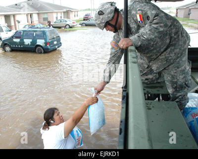 Spc. Timothy C. Berlanga of the Texas Army National Guard hands out a bag of ice to a resident whose neighborhood in Raymondville, Texas was severely flooded July 25 by the deluge of rain from hurricane Dolly.  1st Sgt. Lek Mateo. Stock Photo