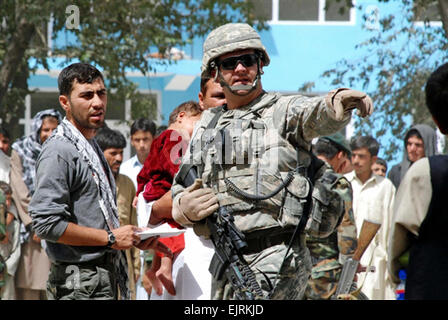 Capt. Joseph Merrill works with a translator to direct a father seeking medical attention for his son. Merrill, a native of Binghamton, N.Y., is a member of the New York National Guard.  Lt. Col. Paul Fanning, Combined Joint Task Force Phoenix Stock Photo