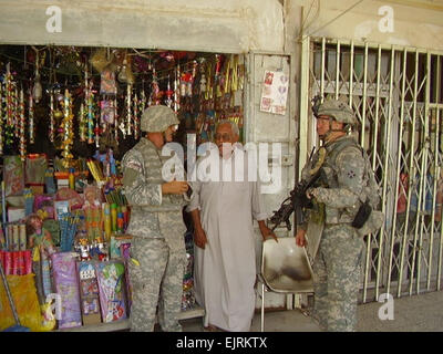 1st Lt. Matthew George, a Los Angeles native, talks with a candle shop owner in northern Baghdad’s Shaab neighborhood with the help of an interpreter during a patrol, Sept. 6, 2008.  1st Lt. Dan Rullo, Multinational Division Baghdad Stock Photo