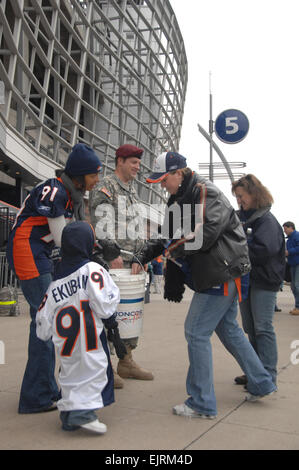 DENVER - Sgt. Joshua Gillespie of the Colorado National Guard along with Karen Ekumban, wife of Defensive Lineman Ebenezer, and their son Ezra, stand outside a gate at Denverís Invesco Field at Mile High among the foot traffic of Broncos fans to help raise money for Colorado's hungry and homeless on Oct. 12, 2008. Soldiers assigned to the Colorado National Guard donated their time to help with the Broncos' Wives Food Drive, which raised more than $37,000.  Staff Sgt. Liesl Marelli Stock Photo