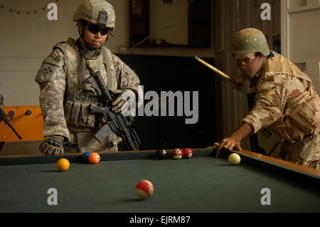 2nd Lt. Critchfield, 1st Platoon, Comanche Company, 2nd Battalion, 8th Infantry Regiment, 4th Infantry Division, Fort Carson, Colo. and a soldier from the 8th division Iraqi army shoot a game of pool at a local arcade while conducting a joint dismounted patrol Oct. 10, 2008 in Ad Diwaniyah, Iraq. Stock Photo