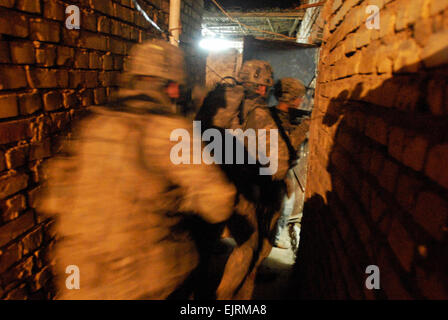 FORWARD OPERATING BASE FALCON, Iraq - Soldiers from Company C, 4th Battalion, 64th Armor Regiment, enter an Iraqi house during an early morning raid Oct. 30 in the Risalah community of southern Baghdadís Rashid district. Co. C, or ìCyclone,î deployed to Baghdad three separate occasions since the start of the war. Soldiers of the 4th Bn., 64th Armor Regt., ìTuskers,î are attached to the 1st Brigade Combat Team, 4th Infantry Division, Multi-National Division ñ Baghdad, and nearing the end of a 15-month deployment in support of Operation Iraqi Freedom. The Tuskers are part of the 4th Brigade Comb Stock Photo