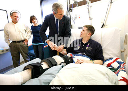 President George W. Bush shakes hands with U.S. Army Staff Sgt.  Kyle Stipp of Avon, Ind., after presenting him with two Purple Hearts Monday, Dec. 22, 2008, during a visit to Walter Reed Army Medical Center where the soldier is recovering from wounds suffered in Operation Iraqi Freedom.   White House photo by Eric Draper. Stock Photo