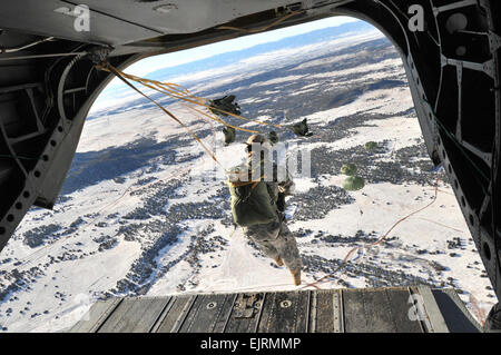 COLORADO SPRINGS, Colo. - Paratroopers assigned to 10th Special Forces Group Airborne conduct airborne operations from a Colorado Army National Guard CH-47D Chinook assigned to 2nd Battalion, 135th Aviation Regiment, into the snow-covered terrain of Fort Carson, Colo., Dec. 10, 2008. The airborne operation conducted under the command of Dutch Special Forces with the assistances of a 10th SFG A jumpmaster, helped familiarize the American paratroopers with Dutch commands. Operations like this help sustain and foster a good working relationship with the Dutch, said a 10th SFG A operations officer Stock Photo