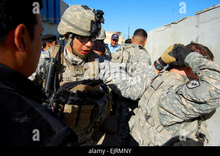 Sgt. Tony Macias, of Wauchula, Fla., demonstrates to an Iraqi police officer the proper way to maintain control of a suspected criminal during a training session held in the Istaqlal Qada, Dec. 29, 2008. Macias is an infantry team leader with Company A, 1st Battalion, 27th Infantry Regiment “Wolfhounds,” 2nd Stryker Brigade Combat Team “Warrior,” 25th Infantry Division, currently attached to 3rd BCT, 4th Inf. Div., Multi-National Division – Baghdad. Stock Photo