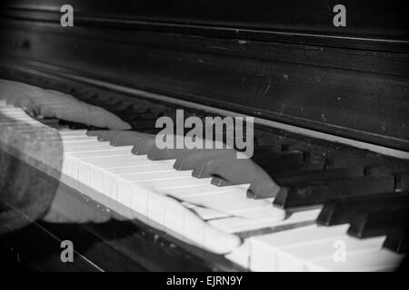 Ghostly hands play an old, dusty piano. Stock Photo