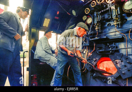 Steam train driving instructor Clive Groom (moustache) with trainees Charlie Johnston (cloth cap) and Bob Baines (black cap). Stock Photo