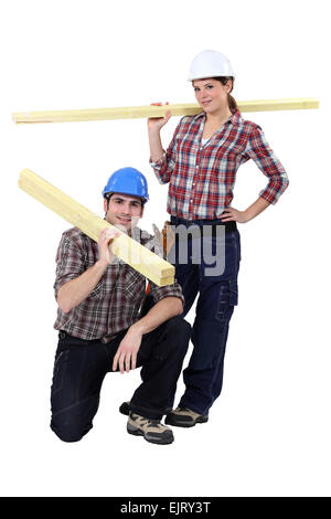 Labourers carrying wooden planks Stock Photo