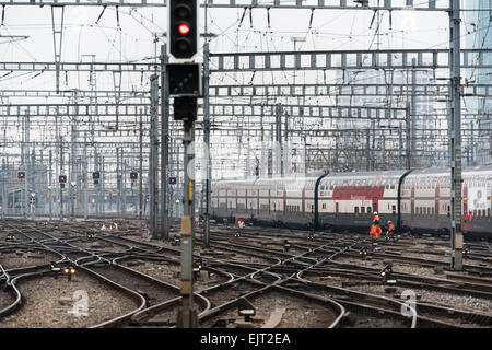 Railway workers and a leaving train on the railway track field of Zurich main station, one of Europe's busiest railway stations. Stock Photo
