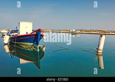 A fishing boat tied up in shallow waters in the city of Lefkada, Greece Stock Photo