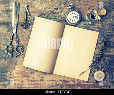 Open book and antique writing tools on wooden table. Stock Photo