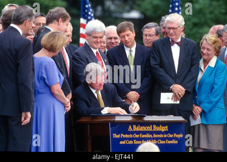US President Bill Clinton signs into law the balanced budget bill during a ceremony on the South Lawn of the White House August 5, 1997 in Washington, DC.  Congressmen Newt Gingrich, John Kasich and others look on. Stock Photo