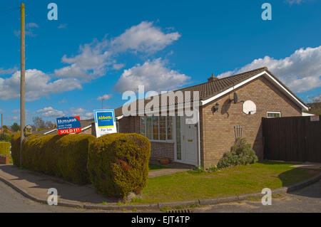 A bungalow with 2 competing Estate Agents boards outside,one saying sold on the board in the Uk Stock Photo