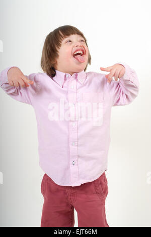 Boy with down syndrome with his tongue sticking out, isolated on white background. Stock Photo