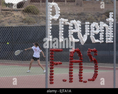 Usa. 31st Mar, 2015. Sports -- The Cibola girls tennis match against Cleveland was used to promote awareness for Fetal Alcohol Syndrome on Tuesday, March 31, 2015. Cibola's Samantha Lambrecht returns serve behind the cups spelling out the FAS message. © Greg Sorber/Albuquerque Journal/ZUMA Wire/Alamy Live News Stock Photo
