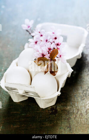 Easter eggs and spring cherry blossoms on wooden table Stock Photo