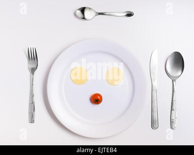 emoticon food, made from cheese, tomatoes, on a plate with cutlery Stock Photo