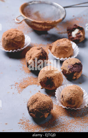 Homemade chocolate truffles with marzipan and cocoa powder over gray matal surface. Stock Photo