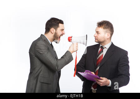 Businessman yelling through a megaphone at a colleague who has a clipboard in hand who is surprised, on white background Stock Photo