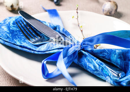 Easter table setting with blue textile napkin, blossom branch and quail eggs Stock Photo