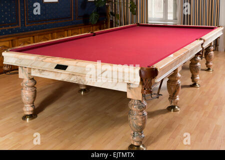 Luxurious marble table with a red cloth for billiard in room with window Stock Photo