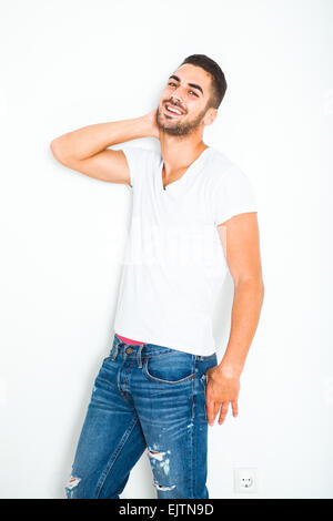 casual young handsome man in white shirt next to a wall Stock Photo