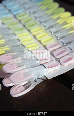 New soft grip plastic clothes pegs clipped on cardboard Stock Photo