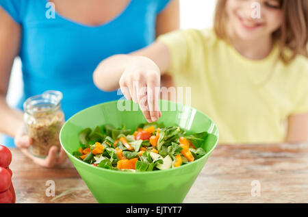 close up of happy family cooking salad in kitchen Stock Photo
