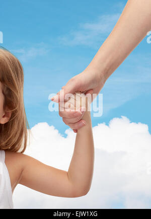 close up of woman and little girl holding hands Stock Photo