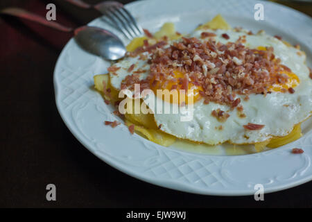 Close up of iberian cured ham, fired eggs and chips Stock Photo