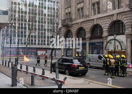 London, UK. 1st April, 2015. An electrical fire in a subterranean substation on Kingsway in central London cause major disruption to local businesses and throughroutes for traffic as flames from ruptured gas pipes vented through pavement and road manholes. Loss of electrical power to local bars and businesses meant the closure of shops and evacuation of offices. Richard Baker / Alamy Live News. Credit:  RichardBaker/Alamy Live News Stock Photo