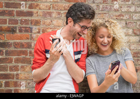 Couple sharing messages on cell phones Stock Photo