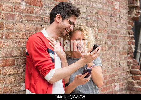 Couple sharing messages on cell phones Stock Photo