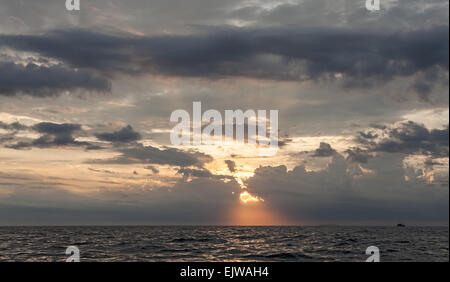Sunset sky with dramatic stormy clouds over ocean. Stock Photo