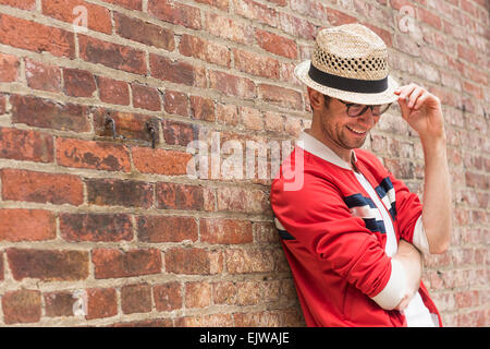 Portrait of mid adult man in front of brick wall Stock Photo