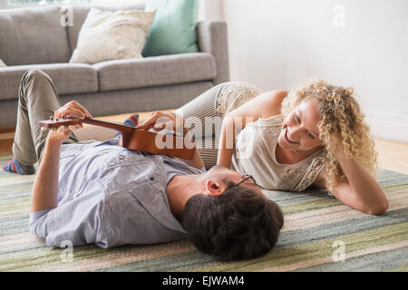 Couple lying on floor playing ukulele Stock Photo