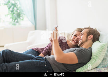 Smiling couple lying on bed and using digital tablet Stock Photo
