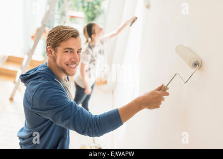 Smiling couple painting wall Stock Photo